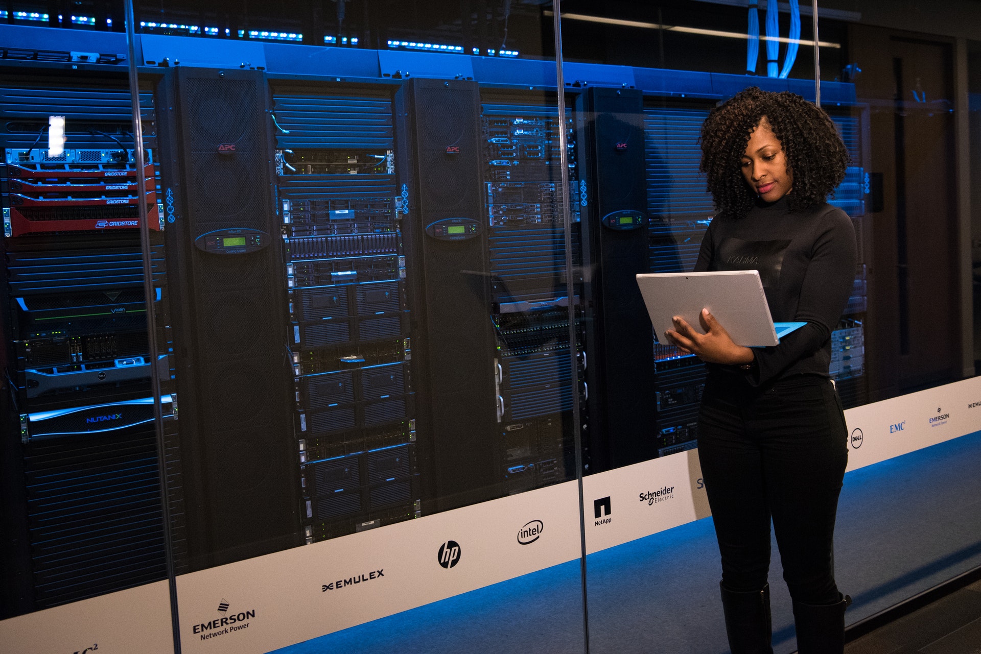 Woman standing next to computer servers